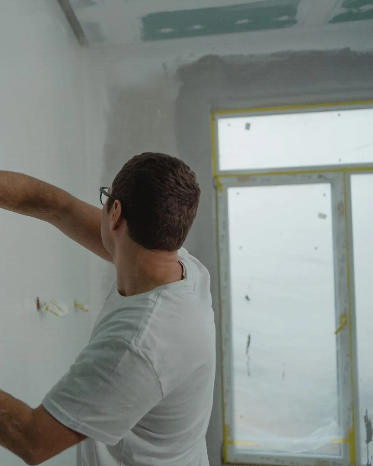 Artisan prenant une mesure sur un chantier de rénovation